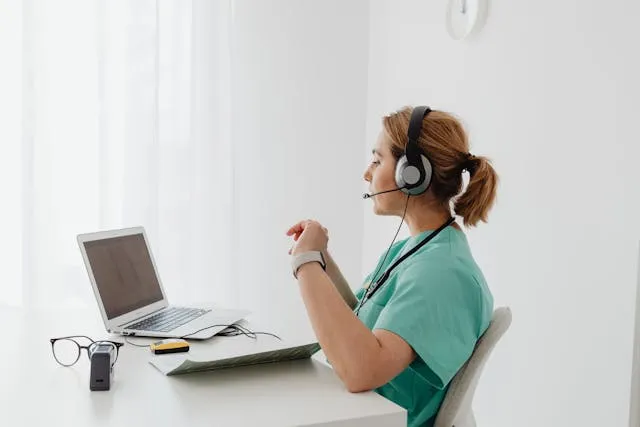 a lady on call with earphone, wearing a green shirt